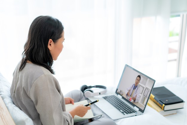 back-view-woman-making-video-call-with-her-doctor-with-her-feeling-sick_73503-2457
